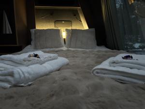 un letto con asciugamani bianchi sopra di Arctic Bear Resort - Lapland - Aurora suite - Sauna - Northern Lights a Ranua Altre 47 foto
