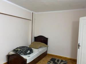 Un pequeño dormitorio con una cama en la esquina en Fully furnished family apartment, en Banī Ghālib