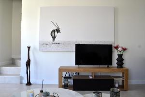 a living room with a tv and a table at Casa Voliere in Stellenbosch +34 photos