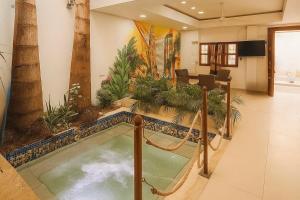 a swimming pool with a swing in a room with palm trees at Casa gimani Betts in Cartagena de Indias