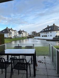 a patio with a table and chairs and a body of water at Let's Go Middelkerke in Middelkerke