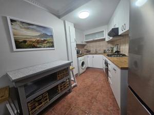 a kitchen with white cabinets and a painting on the wall at Villa Zoe in Glencairn +4 photos