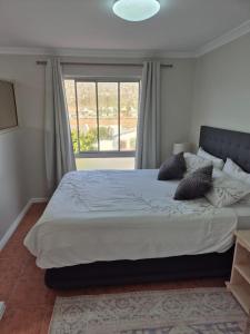 a large bed in a bedroom with a large window at Villa Zoe in Glencairn