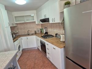 a kitchen with white cabinets and a stainless steel refrigerator at Villa Zoe in Glencairn
