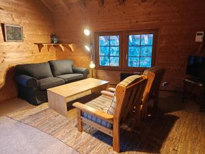 a living room with a couch and a table at Appartement - dans le chalet Carmazin in Morgins