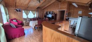 a kitchen and living room with red chairs and a refrigerator at Casa patagonia in Cochrane