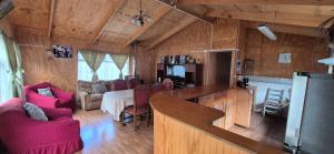 a kitchen and living room with red chairs in a room at Casa patagonia in Cochrane