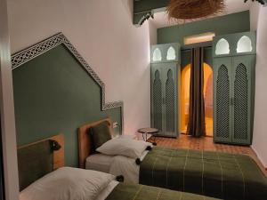 a bedroom with two beds and a mirror at La Douiria Essaouira Medina in Essaouira