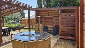 马拉卡韦罗Acogedor Refugio con tinaja y sauna的一个带热水浴缸和桌子的木制露台