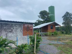 บ่อแก้วโฮมสเตย์的一座小房子，旁边有个游乐场，旁边就是一个筒仓