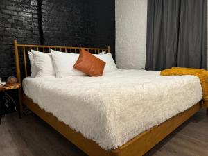 a bedroom with a bed with white sheets and pillows at Jungle House Columbus Downtown Free Parking Sleeps 8 - Steps to Convention Center & Nationwide Arena - 2BR Short North Luxury Home - Over 5,800 Five Star Stays in Columbus