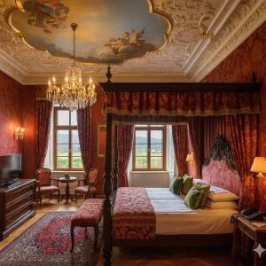 卢捷拿纳德德斯努Zamek Loucna nad Desnou的一间卧室配有一张天蓬床和吊灯。