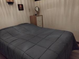 ein Schlafzimmer mit einem Bett mit einer blauen Decke in der Unterkunft Petit nuit doullet in La Grande-Motte