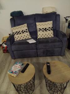 ein Wohnzimmer mit einer Couch und zwei Tischen in der Unterkunft Petit nuit doullet in La Grande-Motte