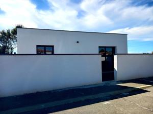 ein weißes Gebäude mit einer weißen Wand und einer Tür in der Unterkunft appartement individuel T2 in Soubise