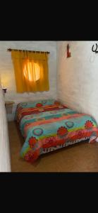 Una cama sentada en una habitación con ventana. en Complejo el trébol, en Potrerillos
