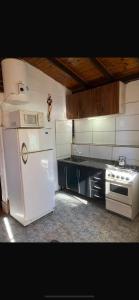 Una cocina con un refrigerador blanco y una estufa. en Complejo el trébol, en Potrerillos