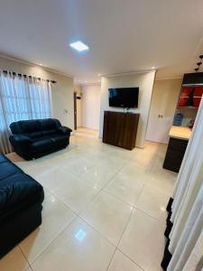 Casa Hohenau, Colonias Unidas في Hohenau: غرفة معيشة مع أريكة وتلفزيون بشاشة مسطحة