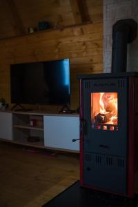 kominek w salonie z telewizorem w obiekcie Vikendica i odmaraliste JuliE, Sarajevo-Jahorina w mieście Tvrdimići