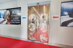 a hotel room with a display case with a bed at SPOT ON Hotel The Comfort Cove in Rānder