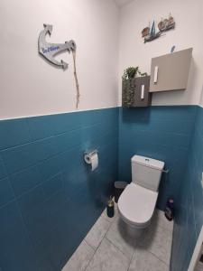 a bathroom with a toilet and blue tiles at Gîte OL'HERON familiale pour 9 personnes à Dolus in Dolus-d'Oléron +10 photos