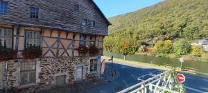 an old building on the side of a road next to a river at Le relais de Victor et son garage à vélos in Revin