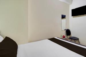 Un dormitorio con una cama blanca y una silla. en HOTEL O A.P PALACE, en Dīgha