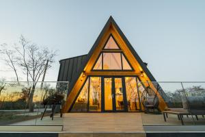 a building with a triangular roof with windows at Domaine A Chalet in Malu Roşu