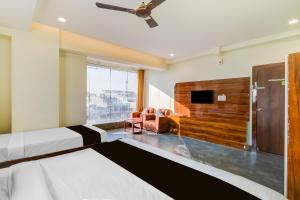 库卡特帕尔莱Hotel O Malani Inn的一间卧室，配有两张床和一台平板电视 更多24张照片