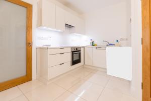 戈尔韦'Amalfi' Coast Road, Oranmore的带白色橱柜和水槽的白色厨房