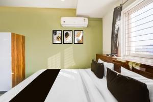 库卡特帕尔莱Hotel O Malani Inn的卧室配有一张墙上三幅照片的床