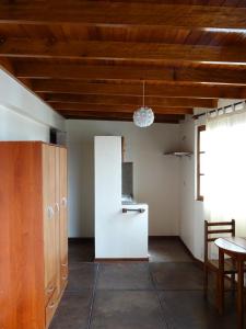 Habitación con techos de madera, mesa y sillas. en Hospedaje La Videna en Lima