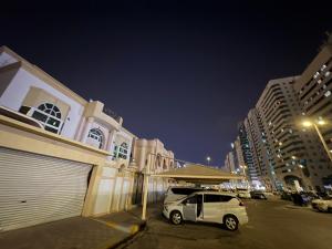 a white car parked next to a building at night at Lang Homes in Abu Dhabi