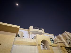 a building with the moon in the sky at Lang Homes in Abu Dhabi