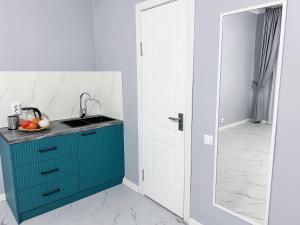 Bekarys Hotel في أستانا: مطبخ مع خزانة زرقاء ومغسلة