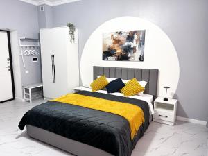 ein Schlafzimmer mit einem großen Bett mit einer gelben Decke in der Unterkunft Bekarys Hotel in Astana