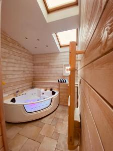 Maison le havre des marées في كابورغ: حوض استحمام كبير في غرفة مع المنور