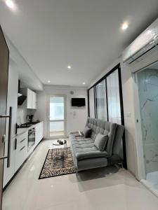 Una sala de estar con un sofá y una cocina. en Appartement à louer, en Sousse