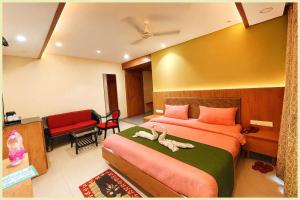 a bedroom with a large bed with two swans on it at Hotel THE RB Near Jagannath Temple And Sea Beach - Parking- Spa With Restaurant - SWIMMING POOL Facilities - Fully Air Conditioning Deluxe Rooms - Prime Location in Puri +11 photos