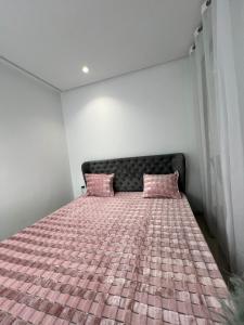 a bedroom with a bed with pink pillows at Appartement à louer in Sousse +6 photos