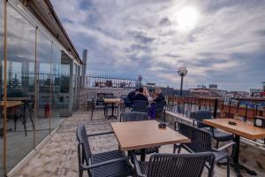 a balcony with tables and chairs on a roof at Sophia Hotel Oldcity in Istanbul