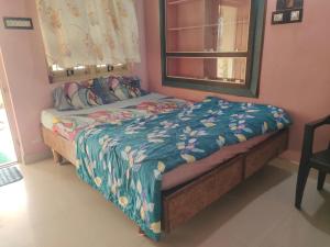 a small bedroom with a bed with a window at Tanvi Guest House Hampi in Hampi