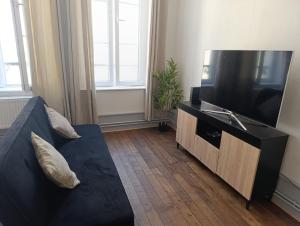a living room with a couch and a flat screen tv at Appartement Cosy du château in Sedan