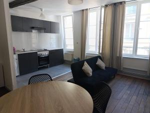 a living room with a blue couch and a table at Appartement Cosy du château in Sedan