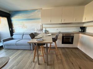 a kitchen and living room with a table and a couch at L'effet Dune in Sangatte +17 photos