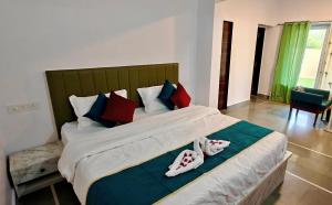 una camera da letto con un grande letto con cuscini rossi e blu di The Jungle Gate Villa a Udaipur Altre 18 foto