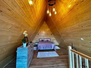 ein Dachzimmer mit einem Bett in einer Holzdecke in der Unterkunft BucovinaAframe in Câmpulung Moldovenesc