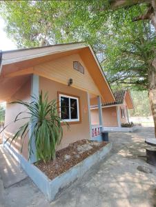 een klein huis met een plant ervoor bij คันทรี รีสอร์ท 