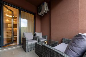 a balcony with wicker chairs and a table and a tv at Queen Lidija in Zlatibor