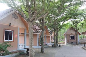 a pink house with trees in front of it at คันทรี รีสอร์ท in Ban Nong Bua